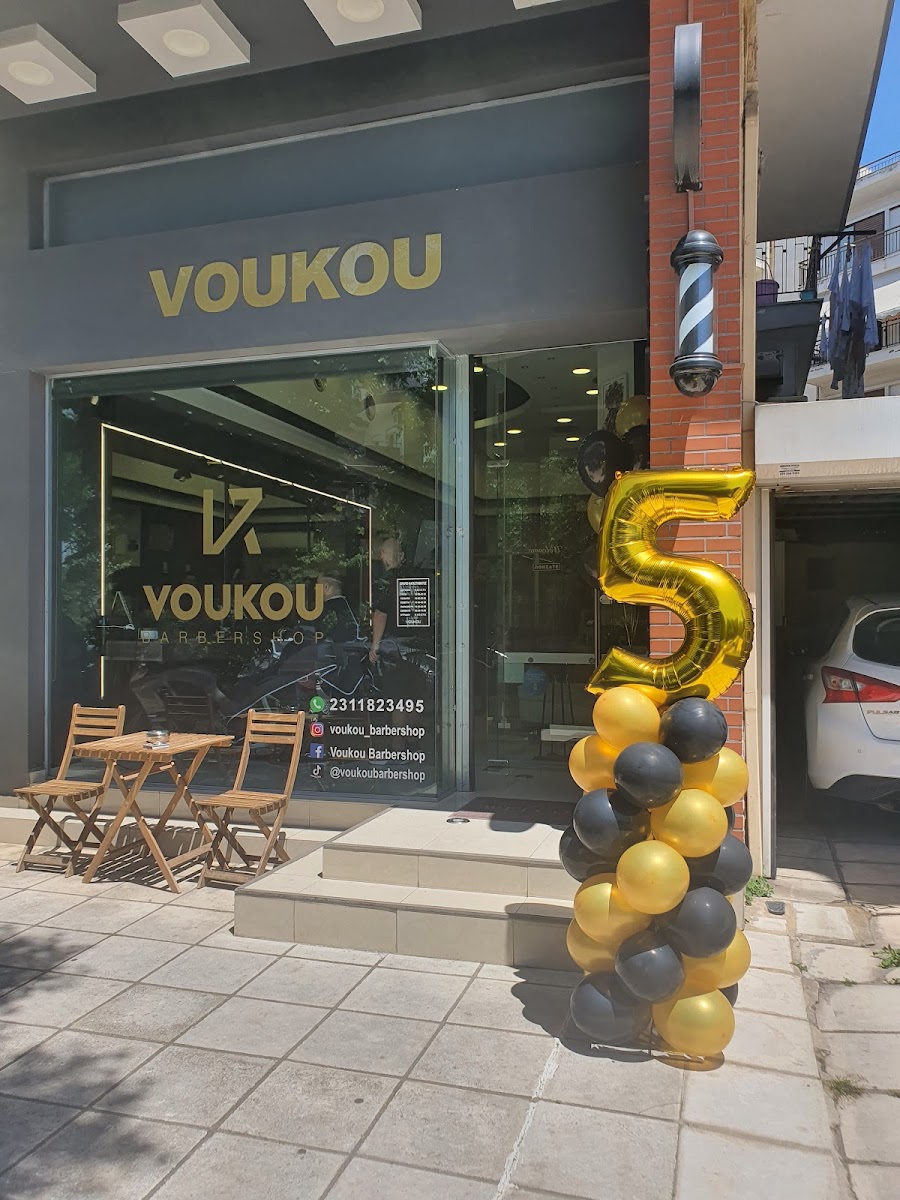 Η βιτρίνα του Voukou Barbershop στη Μεγ. Αλεξάνδρου 10, Σταυρούπολη Θεσσαλονίκης, με τη χρυσή επιγραφή και το κουρεικο φανάρι